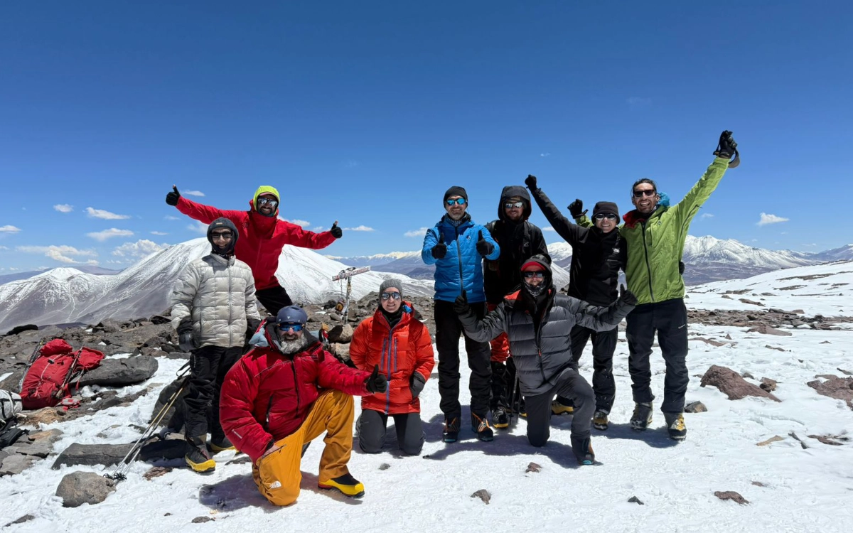 Expedition group celebrating on the 6,018 m summit of Nevado San Francisco volcano during the Ojos del Salado 14-day climb.